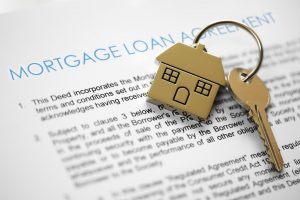 Mortgage loan agreement with house key chain and key on top